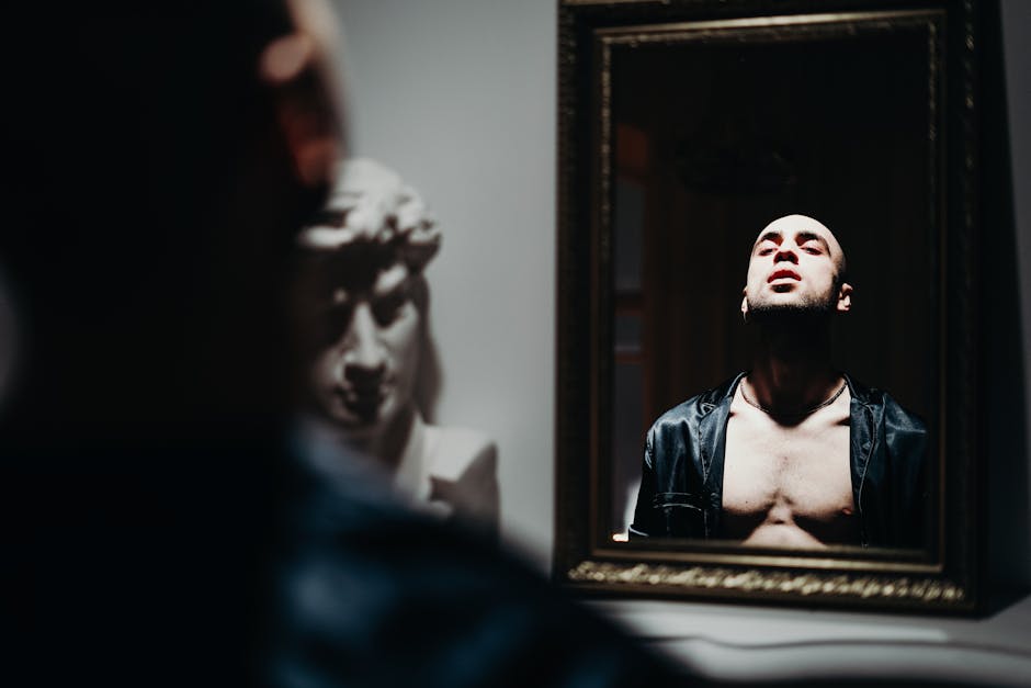 Moody portrait of a man reflecting in a mirror, exploring identity and emotion.